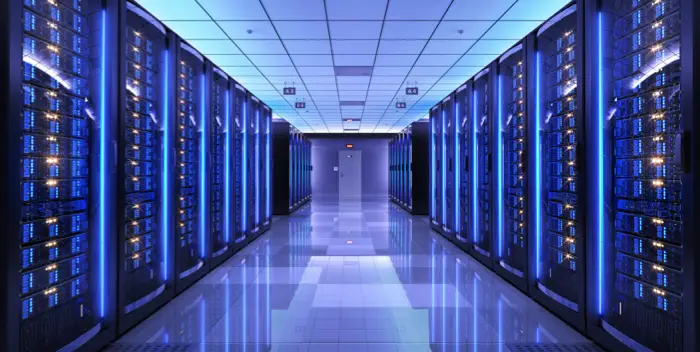 Pasillo frio de racks informaticos en centro de datos disñado e instalado por dtc group con iluminacion LED azul y cableado de fibra optica