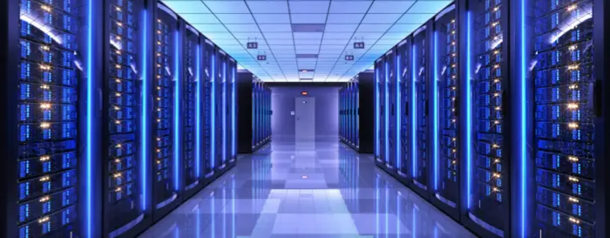 Pasillo frio de racks informaticos en centro de datos disñado e instalado por dtc group con iluminacion LED azul y cableado de fibra optica